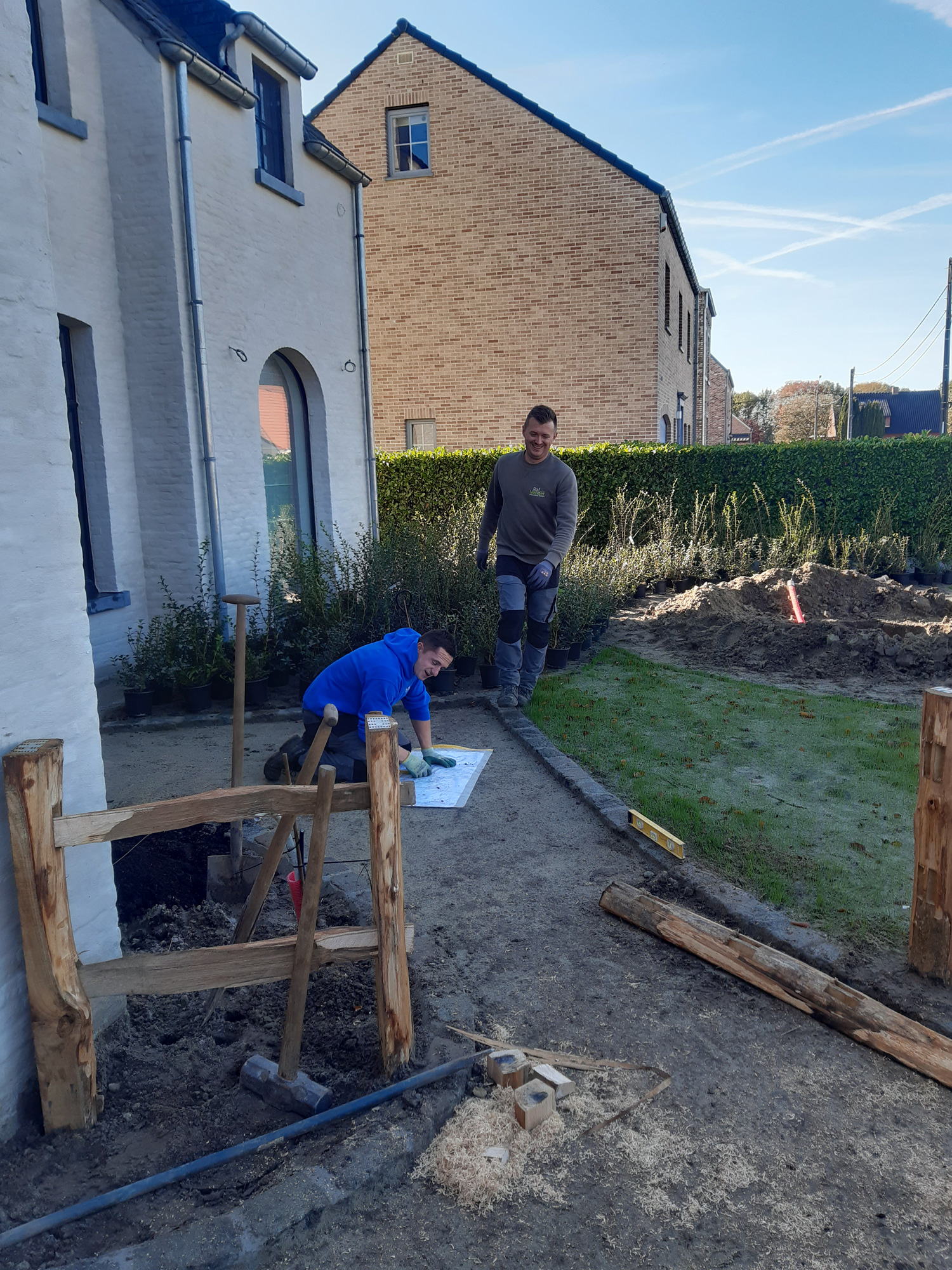 De mannen in actie bij het aanleggen van een tuinpad